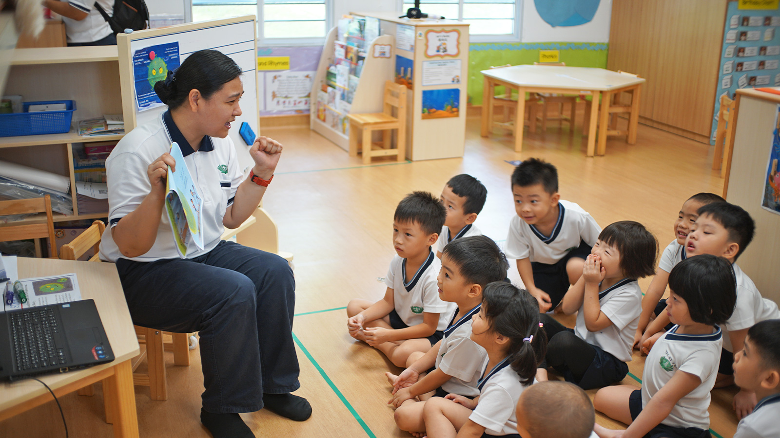 A teacher at Tzu Chi Great Love PreSchool is teaching her students how to protect themselves from the virus outbreak using a picture book.  