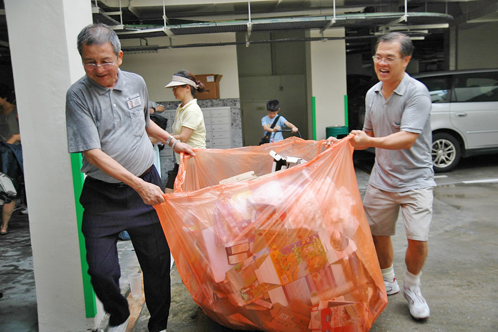 When Mr. Sim Hee Chew was new to Tzu Chi, he was able to readily put aside his status as an owner of a listed company, and worked with volunteer(s) to tidy the collected recyclables at a recycling station.  (Photo by Karen Khoo Pin Joo)