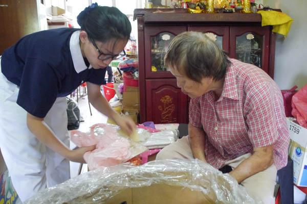 Volunteer Lian Mei’er (left) assures Grandma Wong that she would sort the items according to the latter’s lifestyle habits. Photo by Wu Ming Jun
